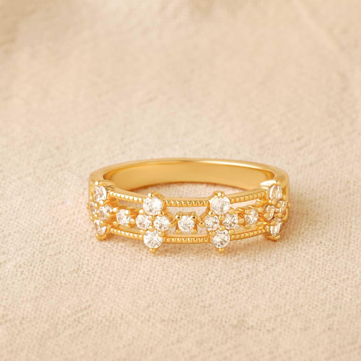 Close-up detail of MYEARS gold cubic zirconia flower band ring design