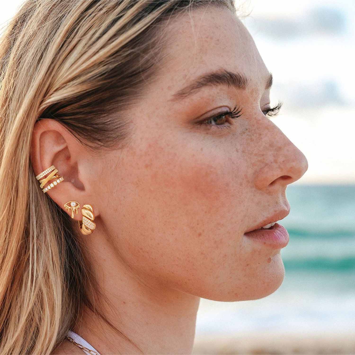 Model wearing MYEARS® dripping pearl evil eye stud earrings, stylish everyday pearl earrings with evil eye charm for women.