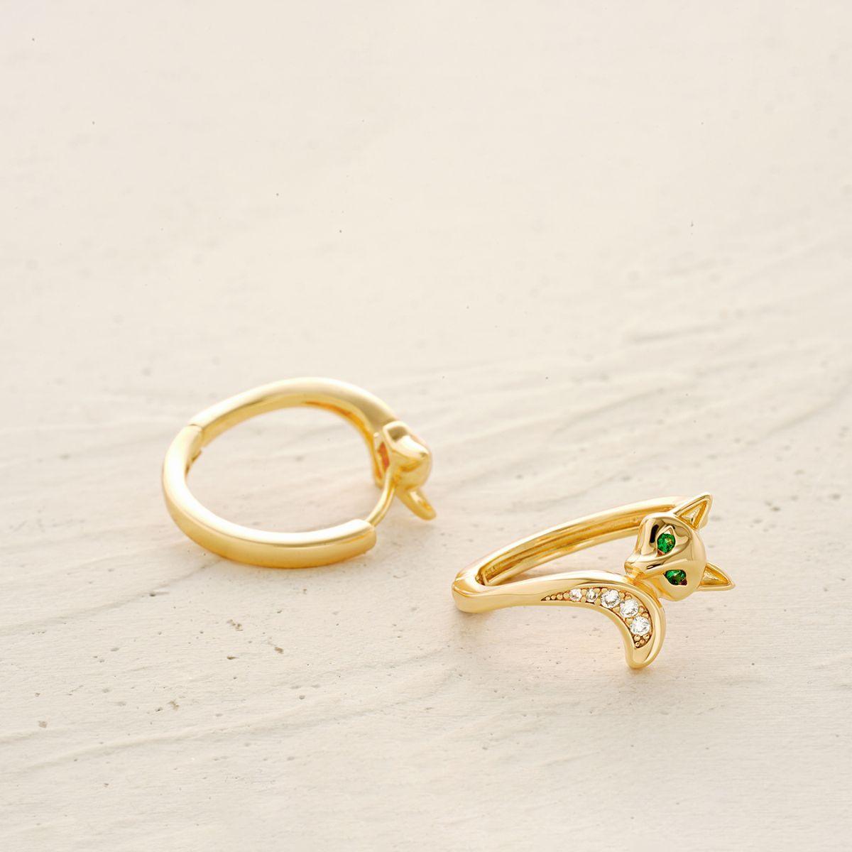 Extreme close-up detail of the fox‘s face, featuring brilliant green gemstone eyes and delicate gold filigree on these hoop earrings