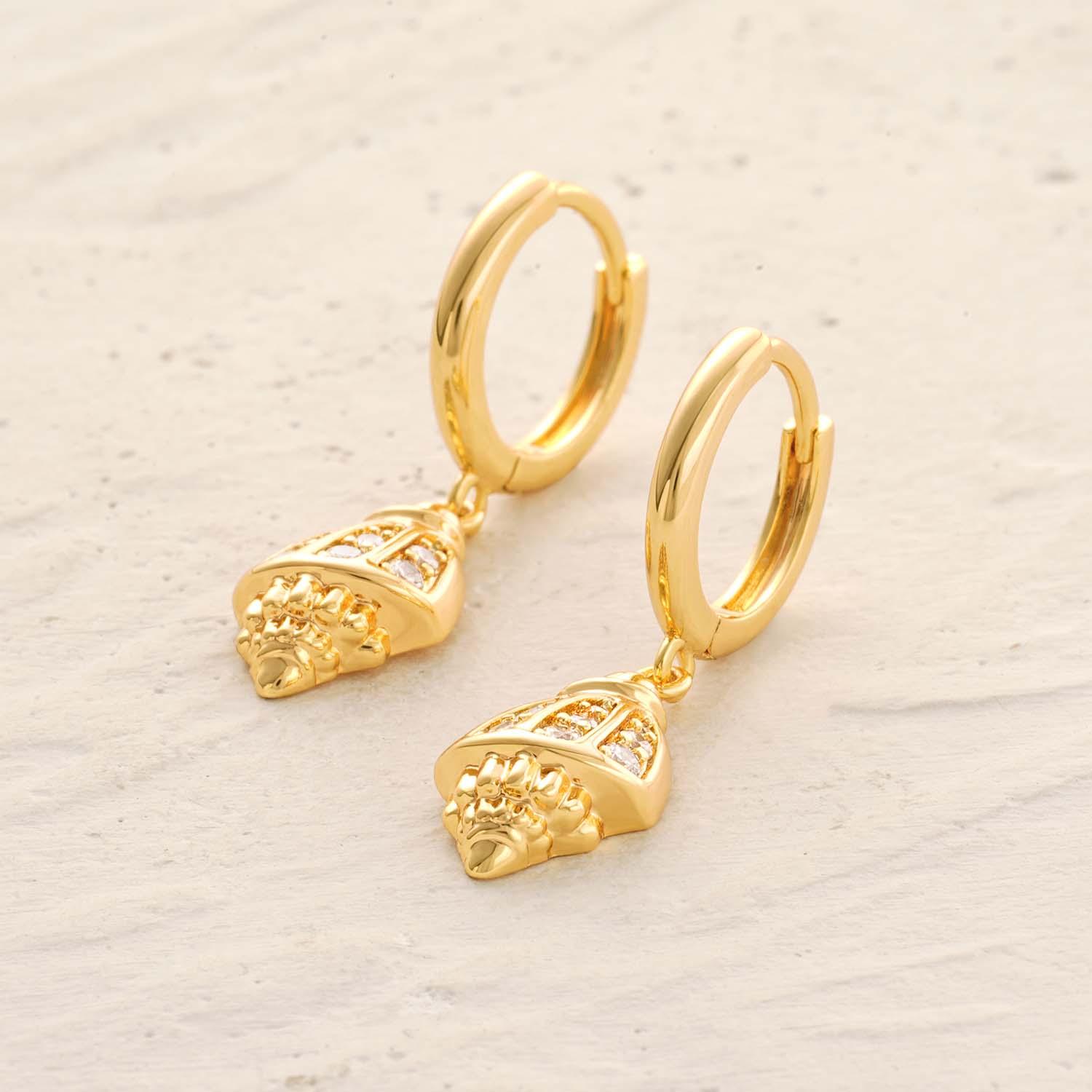 Detailed view of MYEARS® conch shell drop earrings highlighting the sculpted shell design and polished gold finish.