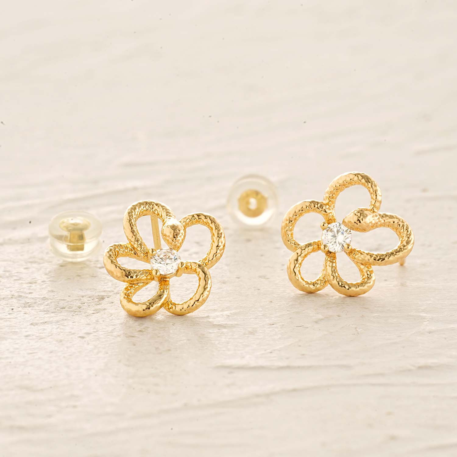 Close-up detail of MYEARS gold snake flower stud earrings design