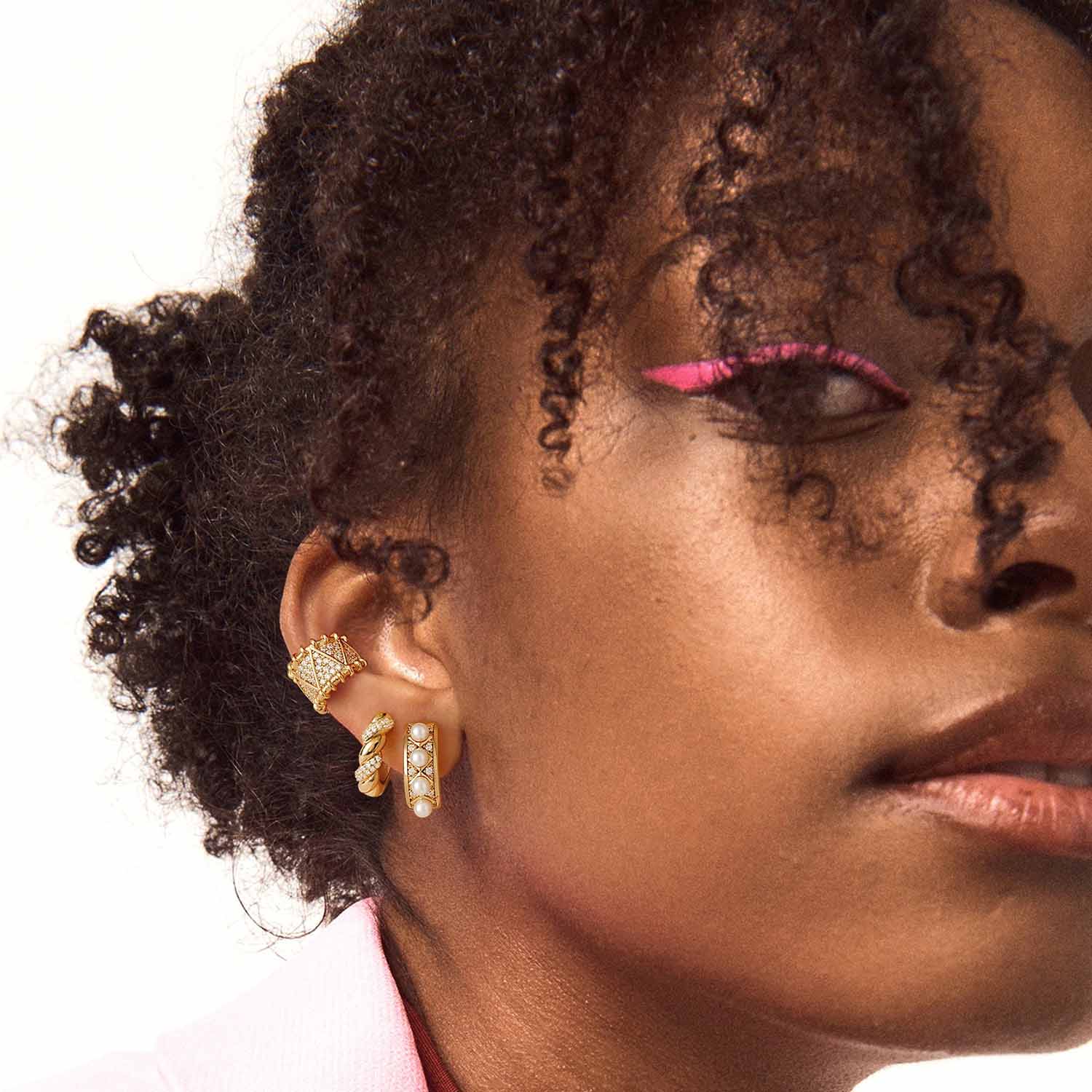Close-up of a model wearing MYEARS® pearl huggie hoop earrings, 14K gold finish, stylish pearl huggie earrings for women.