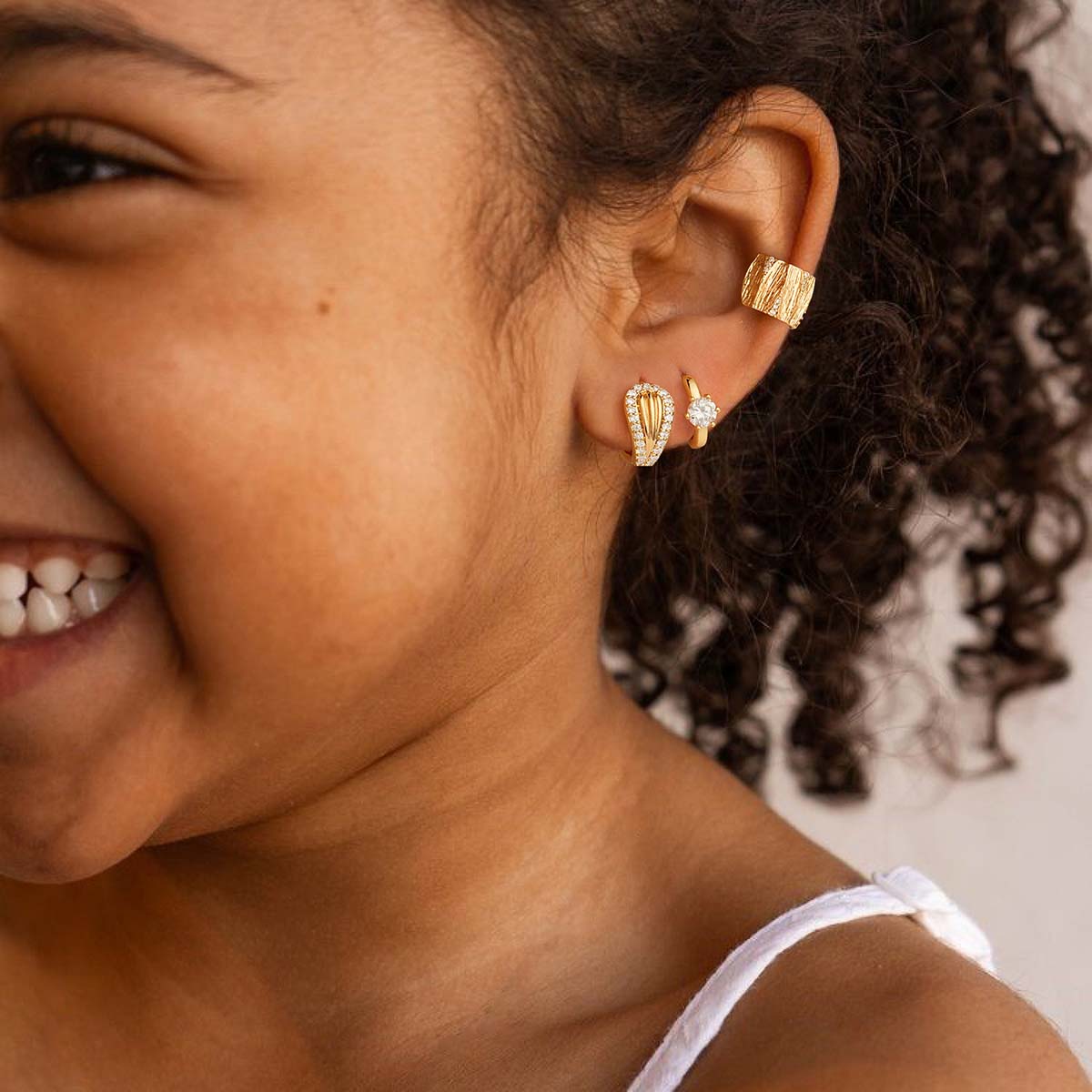 Woman wearing MYEARS® CZ Mermaid Tail Huggie Hoop Earrings in gold, showing a delicate mermaid tail shape that adds a subtle sparkle to daily outfits