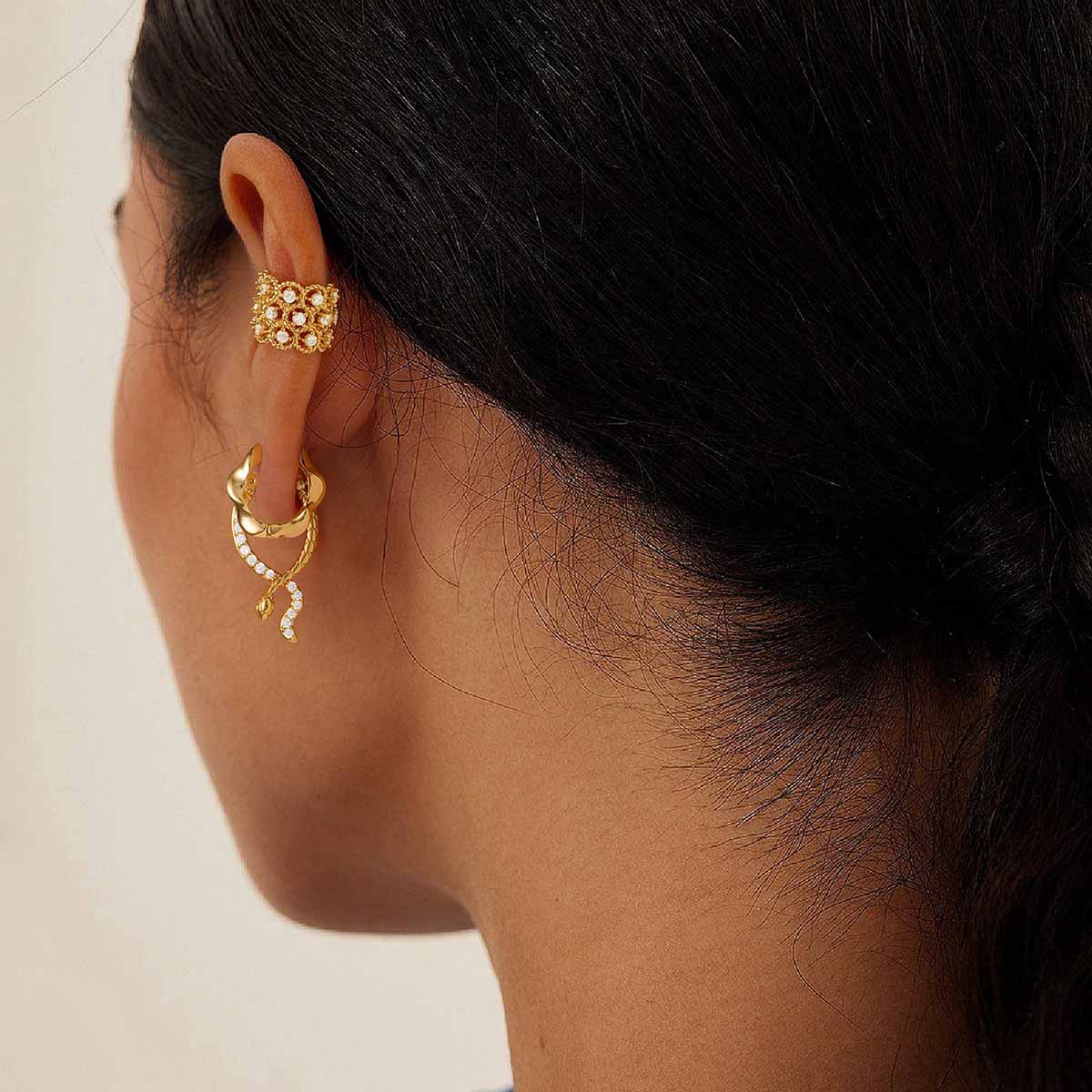 Close-up of MYEARS® CZ snake hoop earrings in gold on model, highlighting the snake-inspired curves