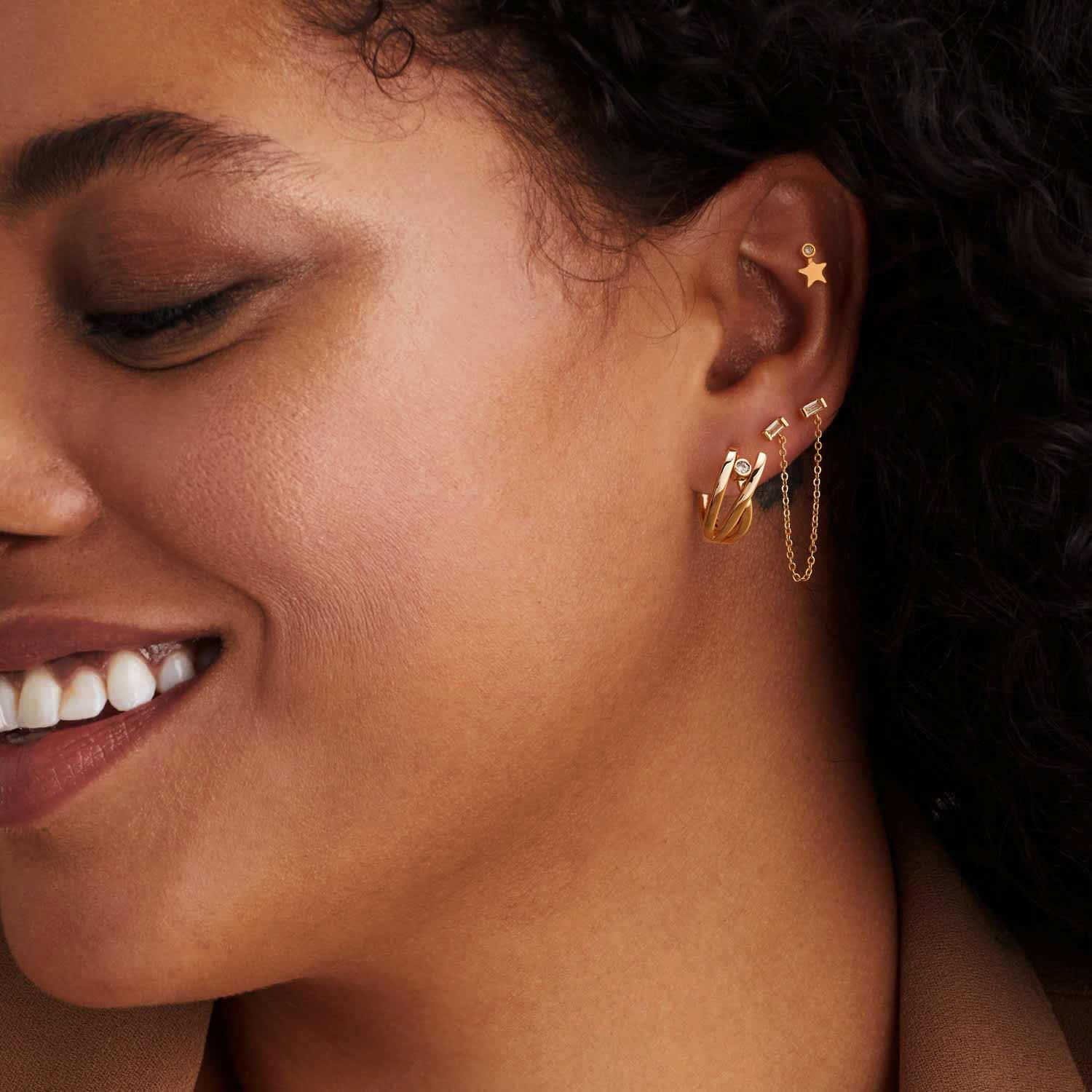 Model wearing MYEARS gold chain dangle stud earrings