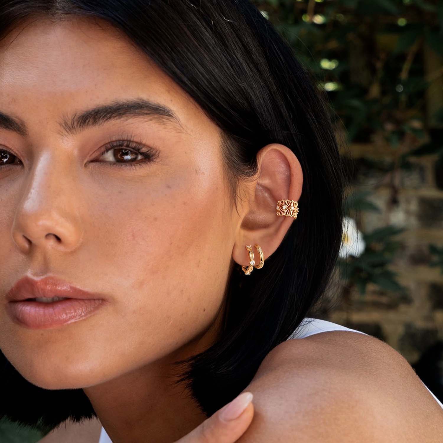 Woman wearing MYEARS® Knot CZ Hoop Earrings in gold, stylish hoop earrings suitable for casual and formal outfits