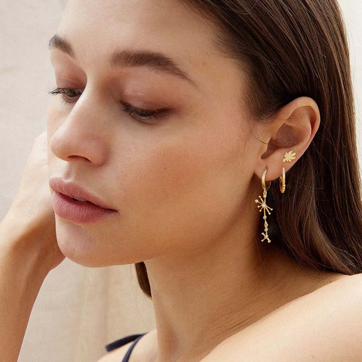 Close-up of MYEARS® star dangle earrings in gold on model, lightweight jewelry designed for women and