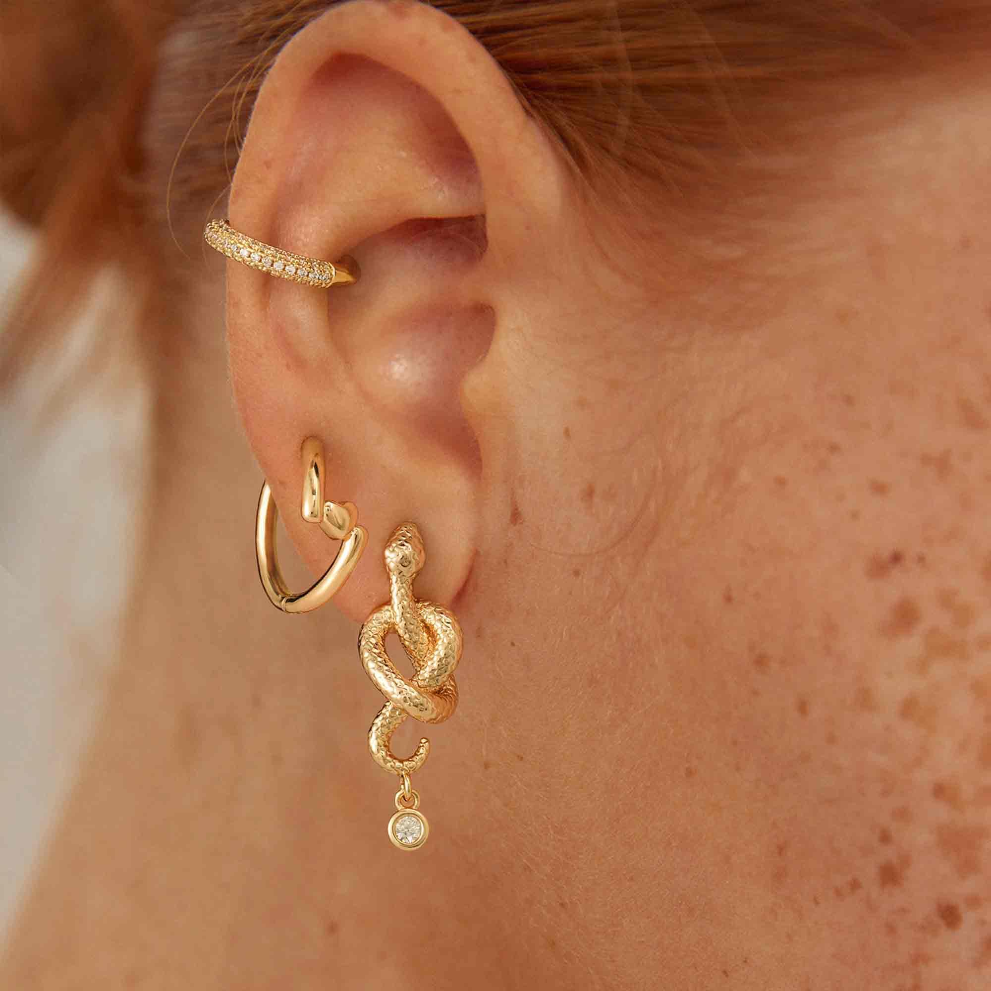 Model wearing MYEARS Heart Hinged Huggie Hoop Earrings in gold, small heart huggie hoops for women