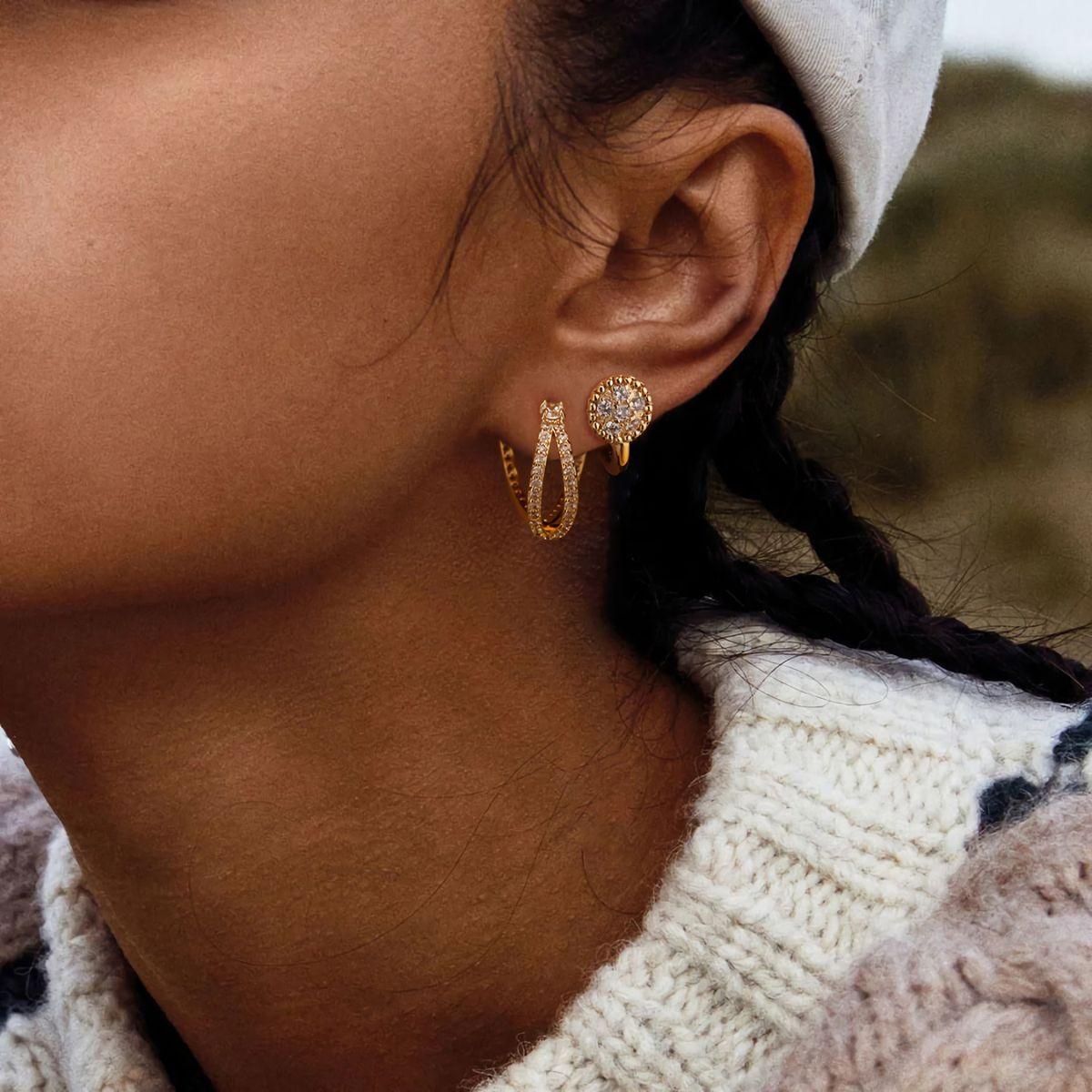 Close-up of MYEARS® Pave Disc Hoop Earrings worn by a woman, showcasing gold hoops adorned with sparkling pave discs