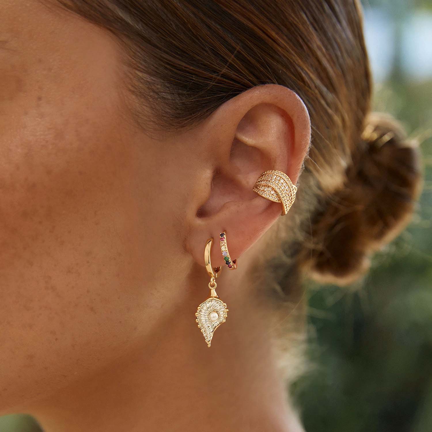 Model wearing MYEARS® rainbow huggie hoop earrings, small colorful gold hoops for women, perfect for everyday wear and gifting.