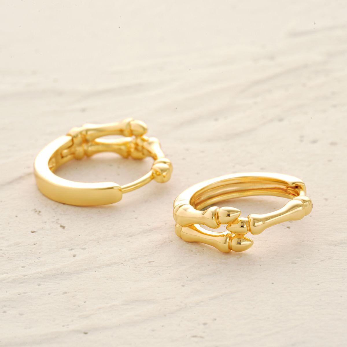 Detail of MYEARS® skull hand hoop earrings showing sculpted skull hand design in gold