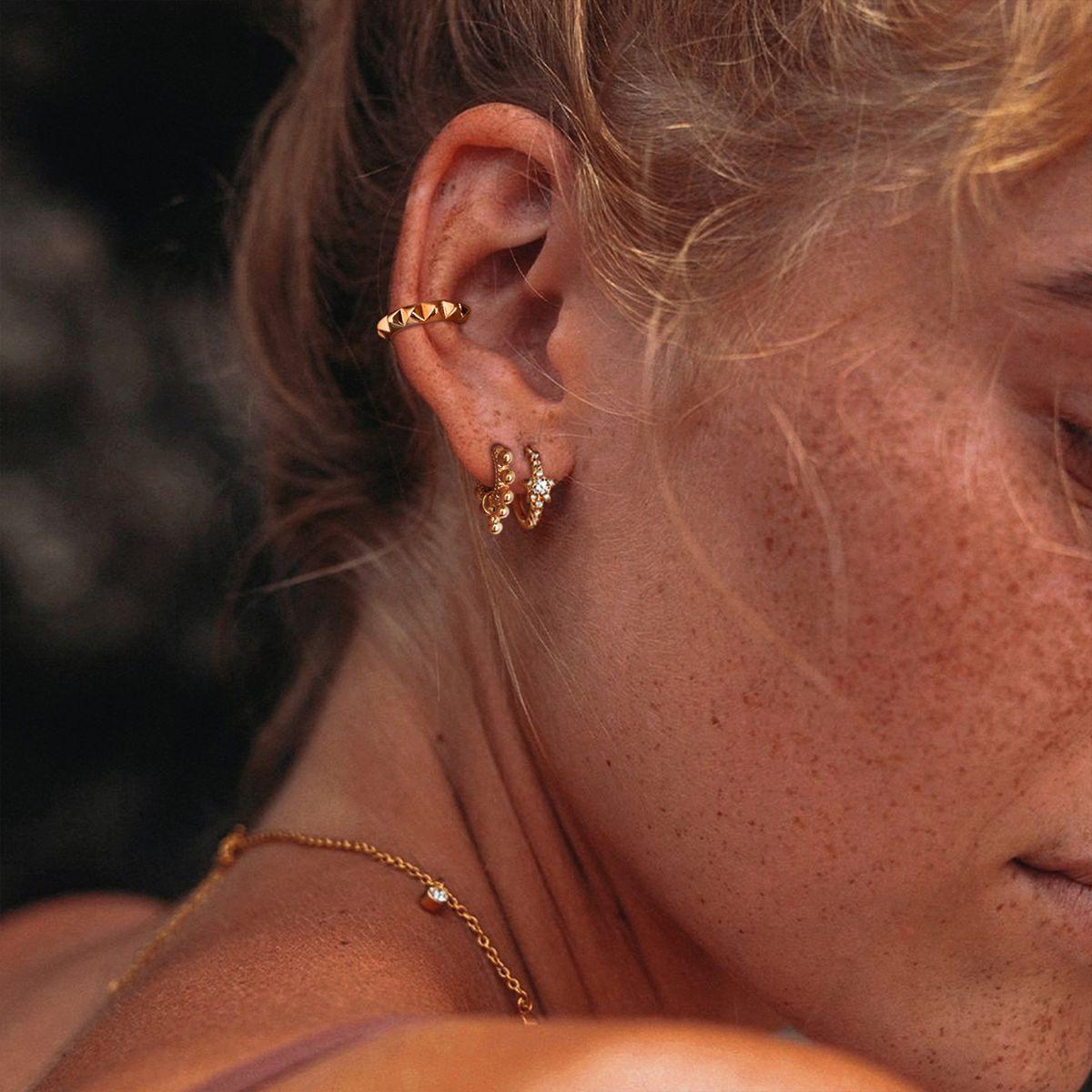 Close-up of MYEARS® Star Huggie Hoop Earrings in gold, elegant jewelry accessory for women