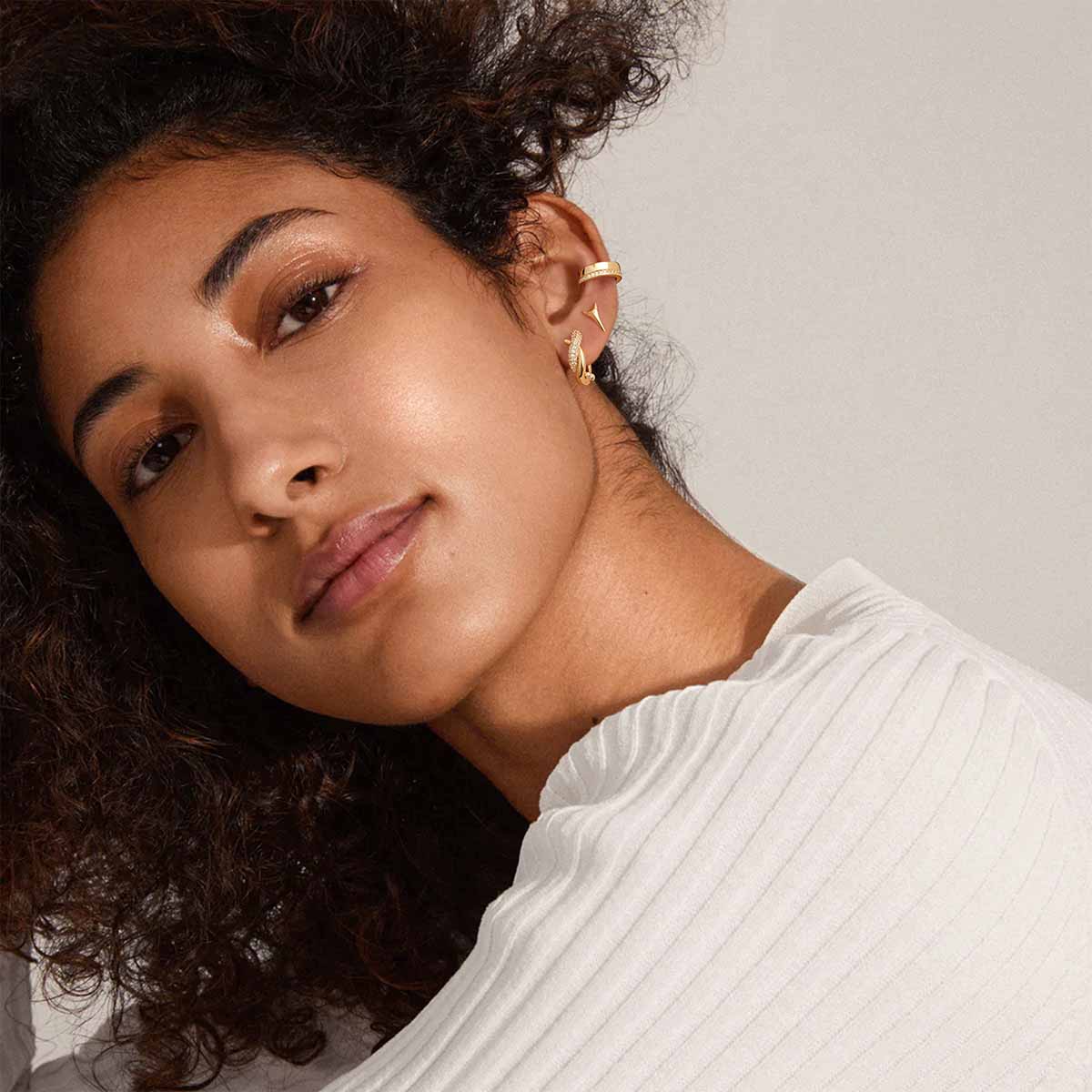 Close-up of MYEARS® Twisted CZ Hoop Earrings in gold on model, highlighting the twisted shape