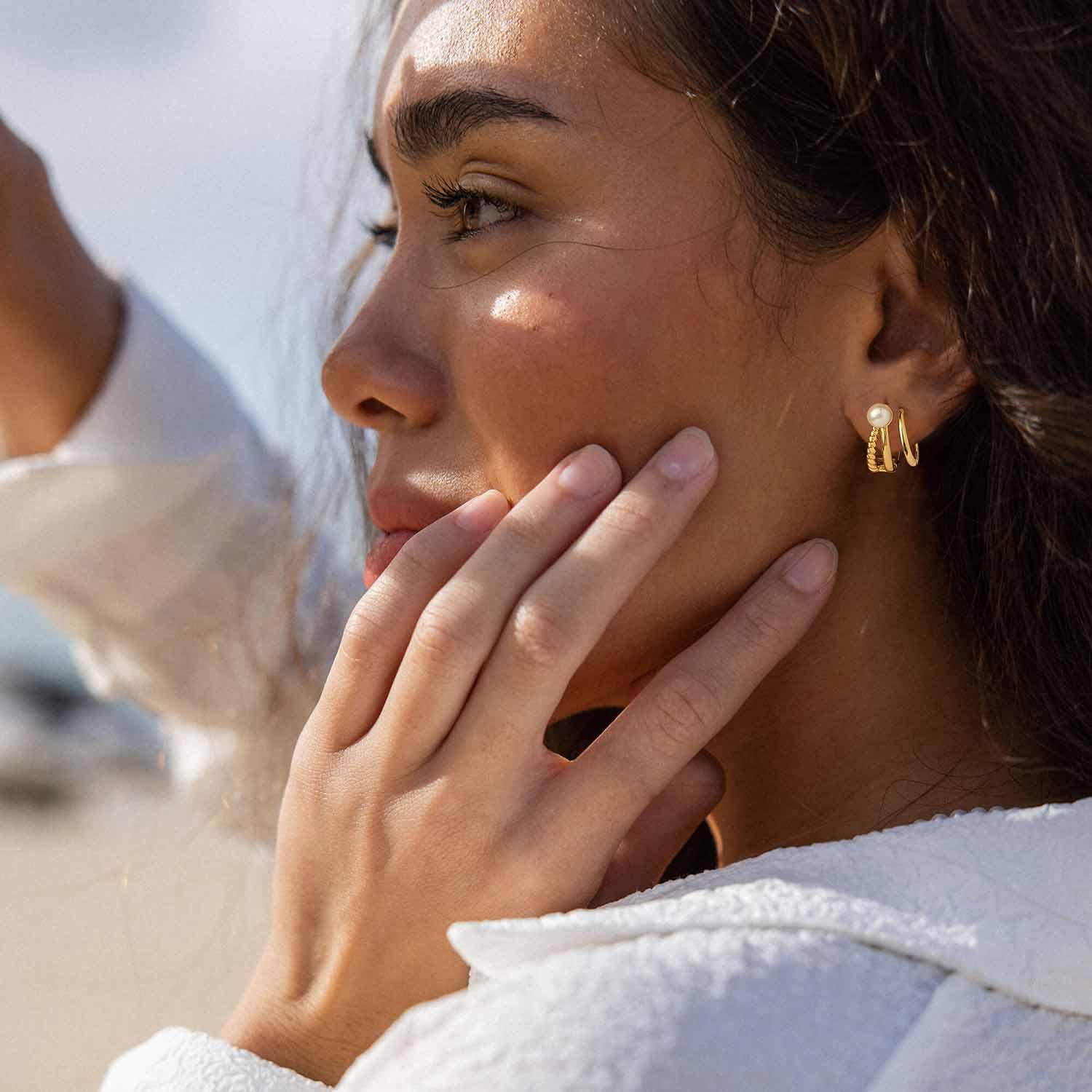 Close-up of a model wearing MYEARS® twisted split pearl hoop earrings, stylish twisted split pearl hoop earrings for women.