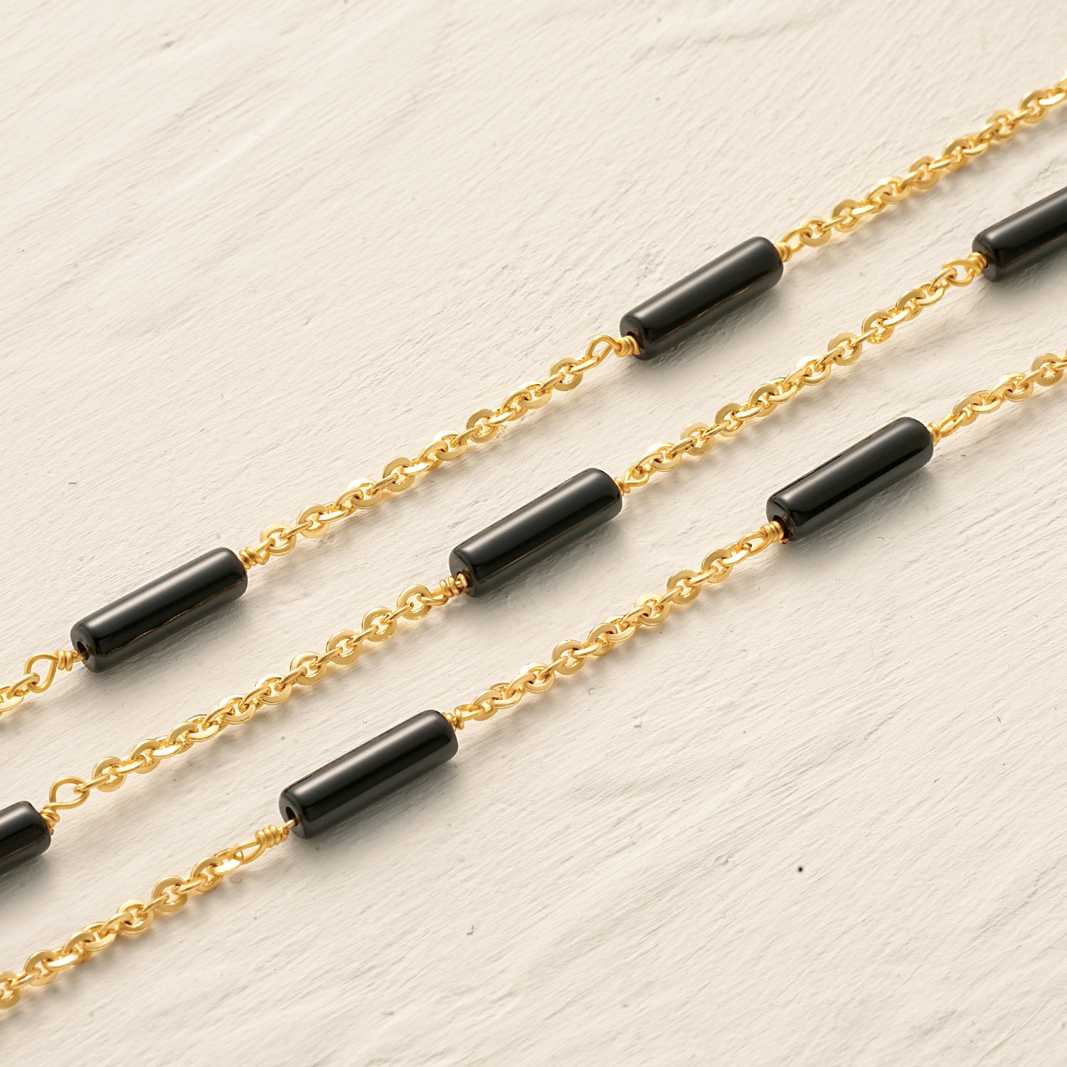 Detail shot of the Myears® black onyx choker necklace showing the 14k gold-plated chain and polished black onyx pendant