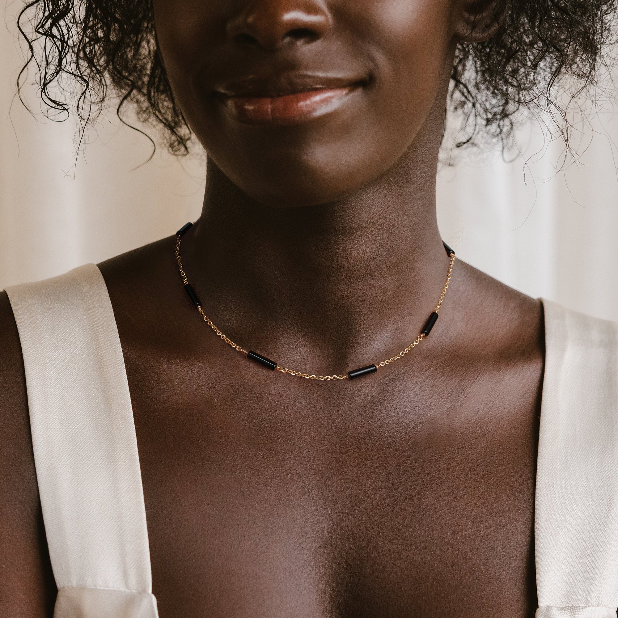 Model wearing the Myears® black onyx choker necklace in a natural daily outfit look