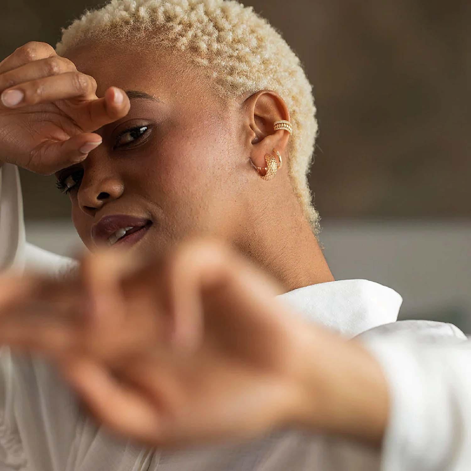 Chunky snakeskin huggie hoop earrings in gold styled for everyday wear, fashionable jewelry for women