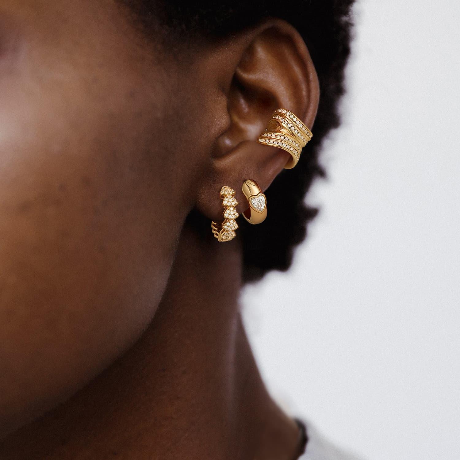 Model wearing Myears® heart huggie hoop earrings, stylish heart-shaped gold hoop earrings for women’s everyday wear.