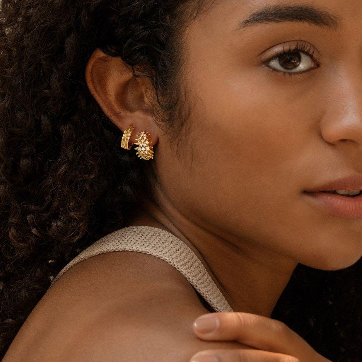 Close-up of MYEARS® Anemone Pearl Huggie Hoop Earrings worn by a woman, showing delicate gold hoops with pearl accents
