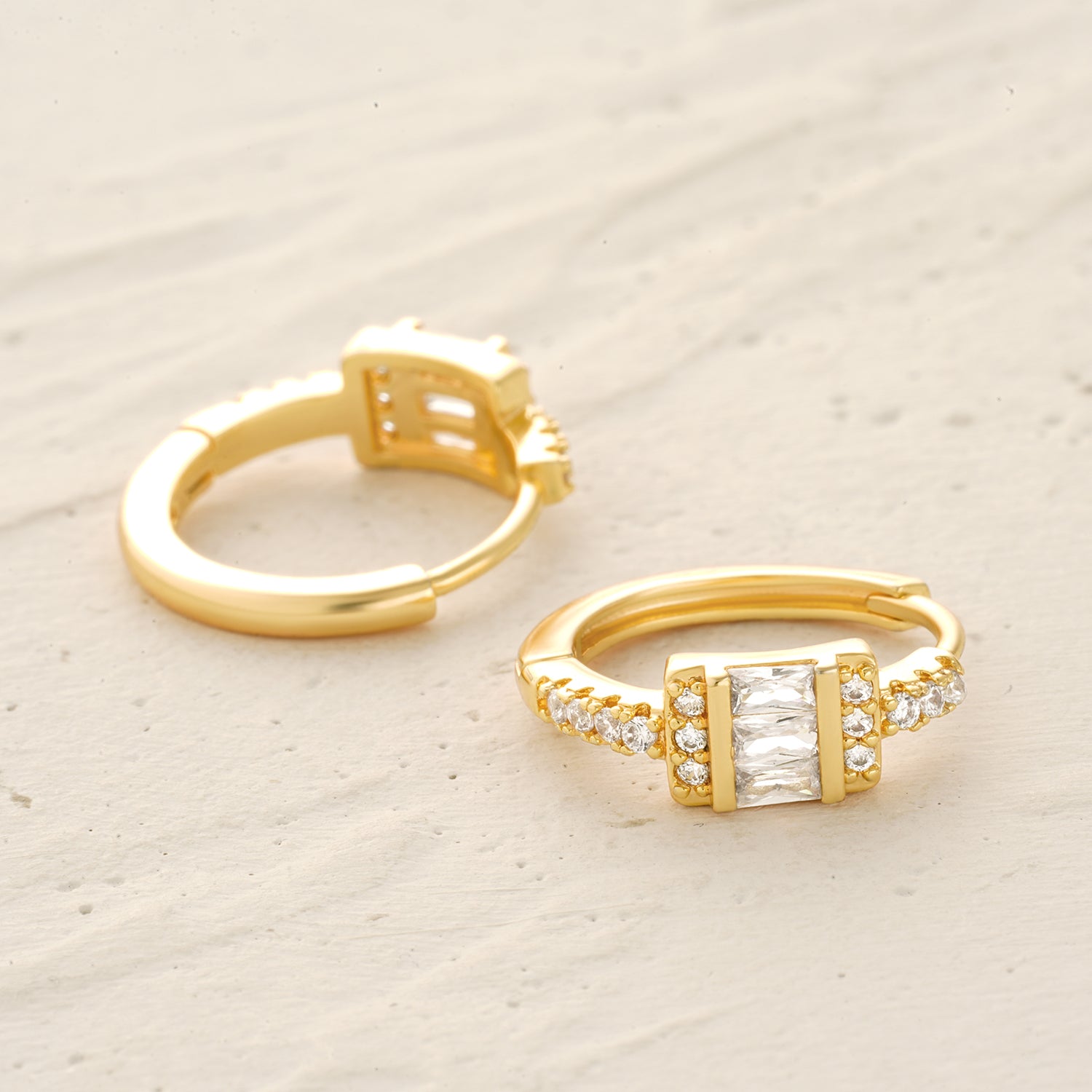 Detail scene of MYEARS® baguette CZ hoop earrings in gold, focusing on the geometric baguette stones