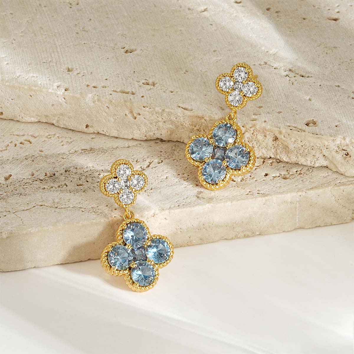 Close-up detail of MYEARS gold Clover Flower March birthstone dangle stud earrings