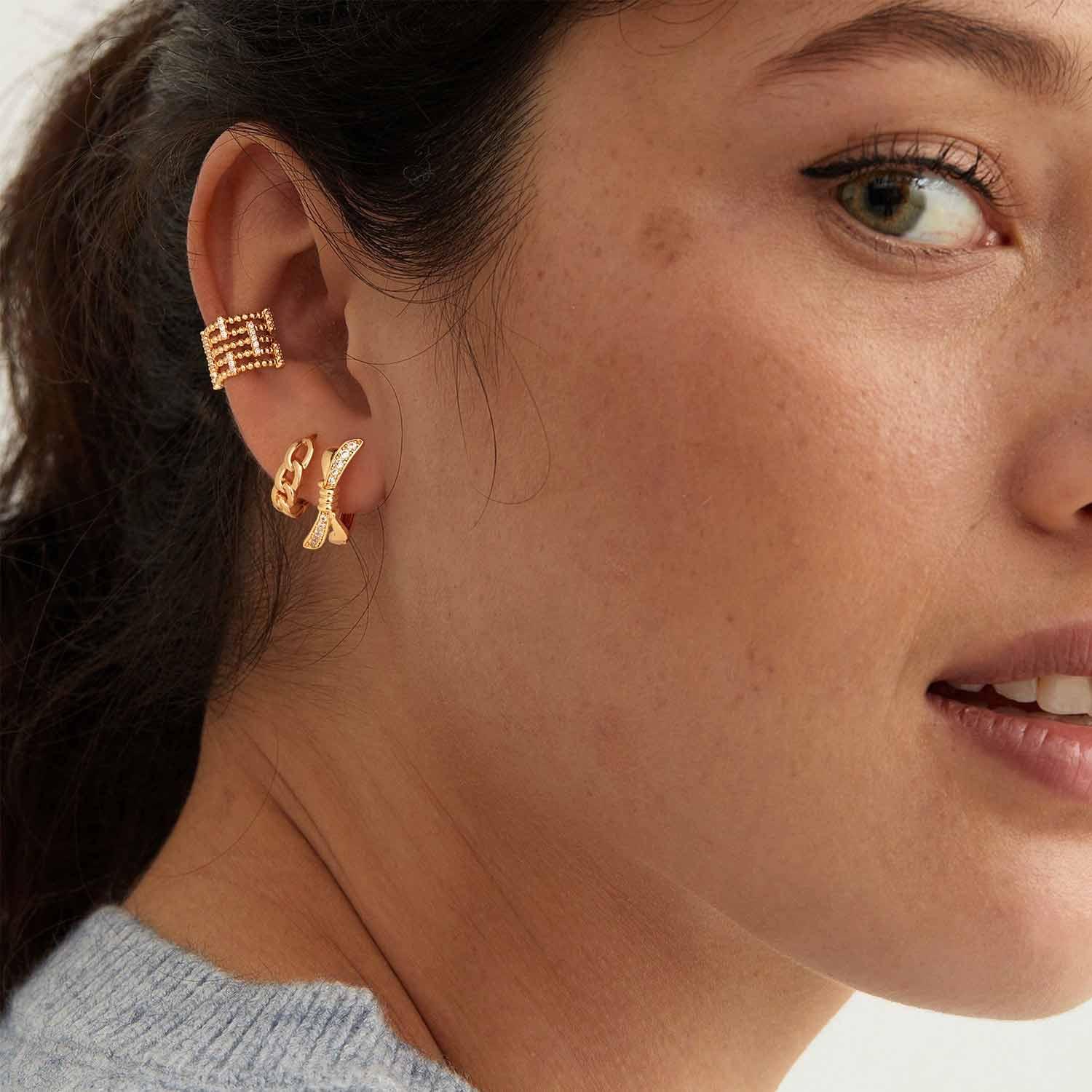 Close-up of a model wearing MYEARS® Cuban Chain Link Hoop Earrings, 14K gold, showing Cuban chain detail, chic and modern earrings for women, perfect gift and everyday wear accessory.