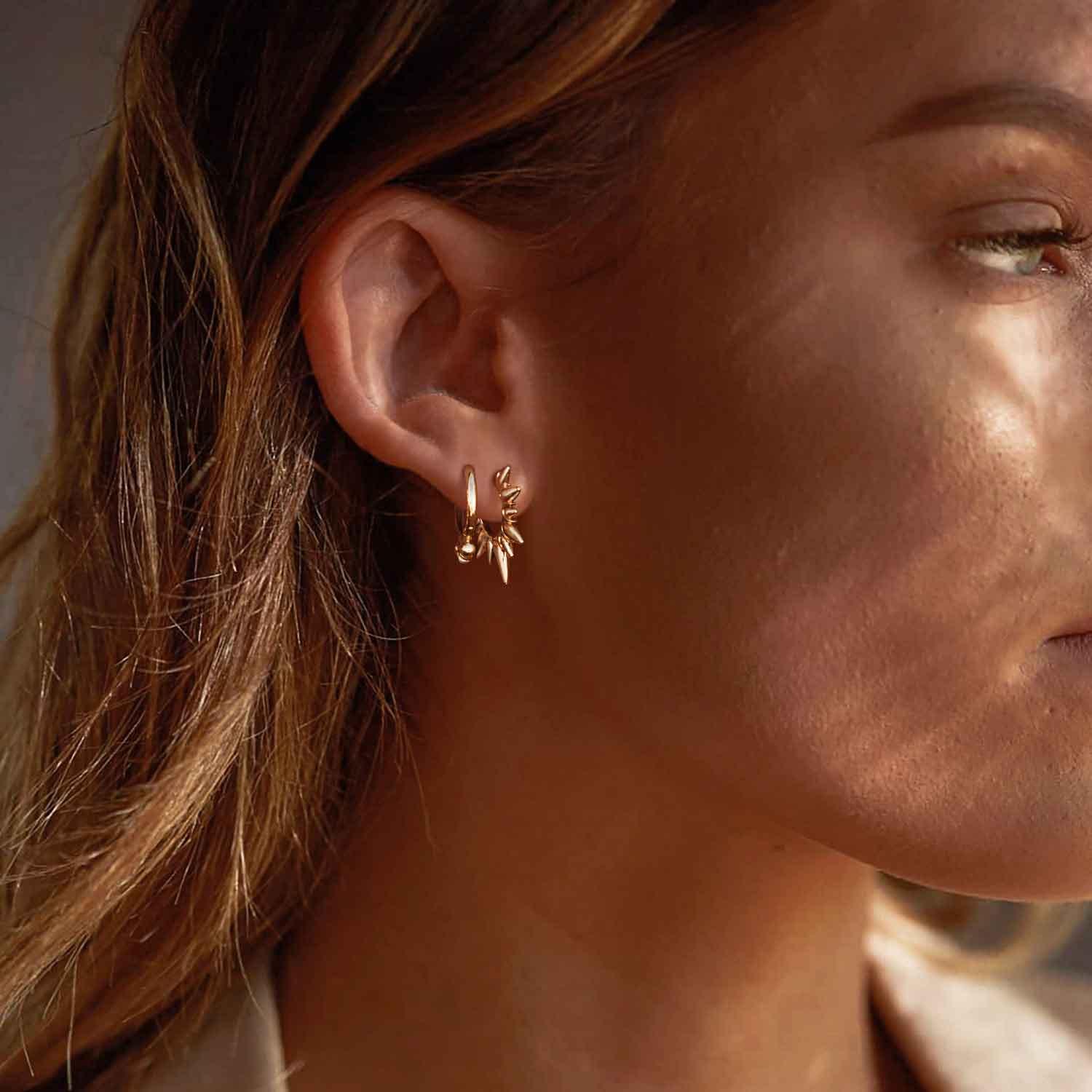 Close-up of MYEARS® Gold Sunbeam Spike Hoop Earrings worn by model, elegant gold hoops for women, detailed spike design