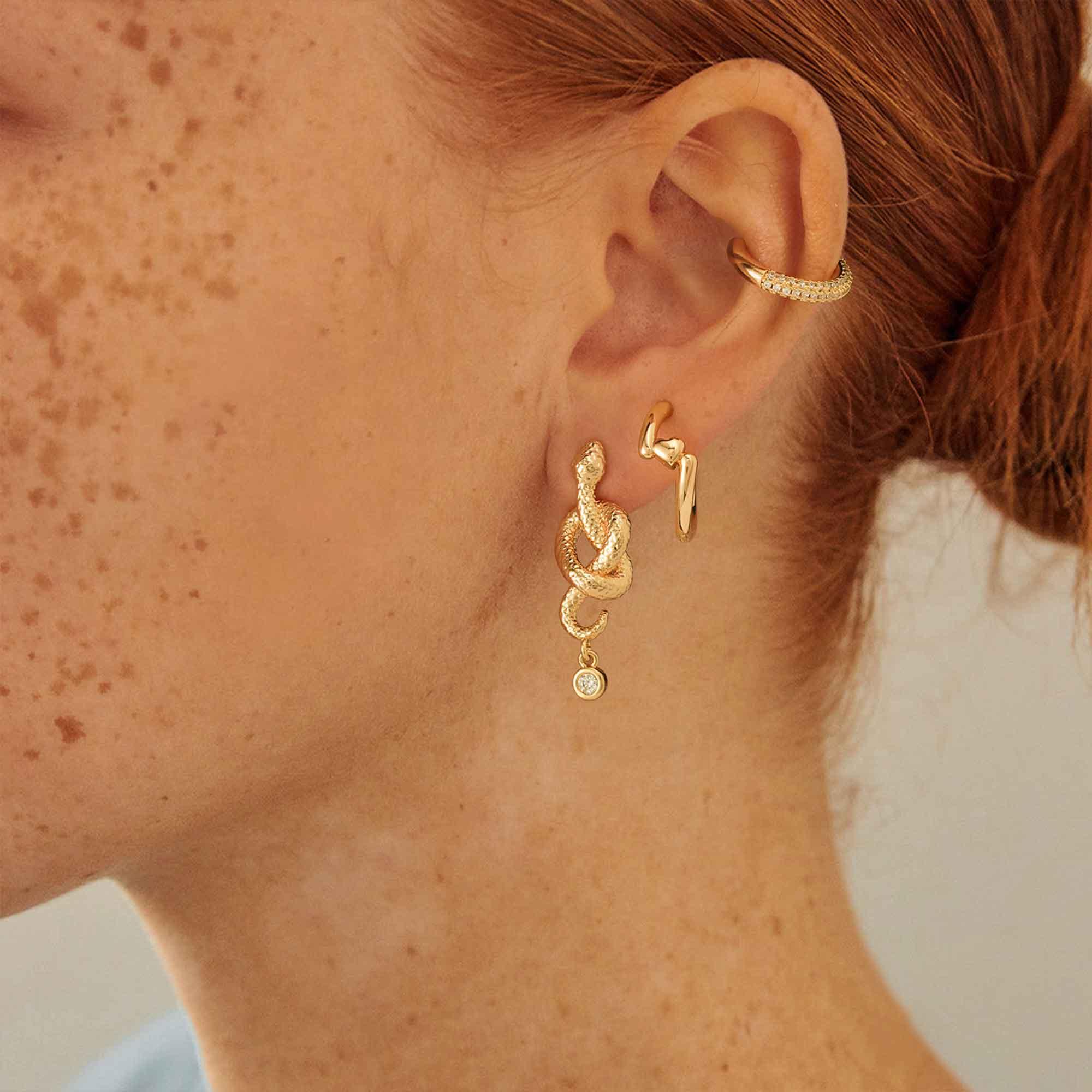 MYEARS Heart Hinged Huggie Hoop Earrings worn by a woman, gold huggie hoop earrings suitable for everyday wear