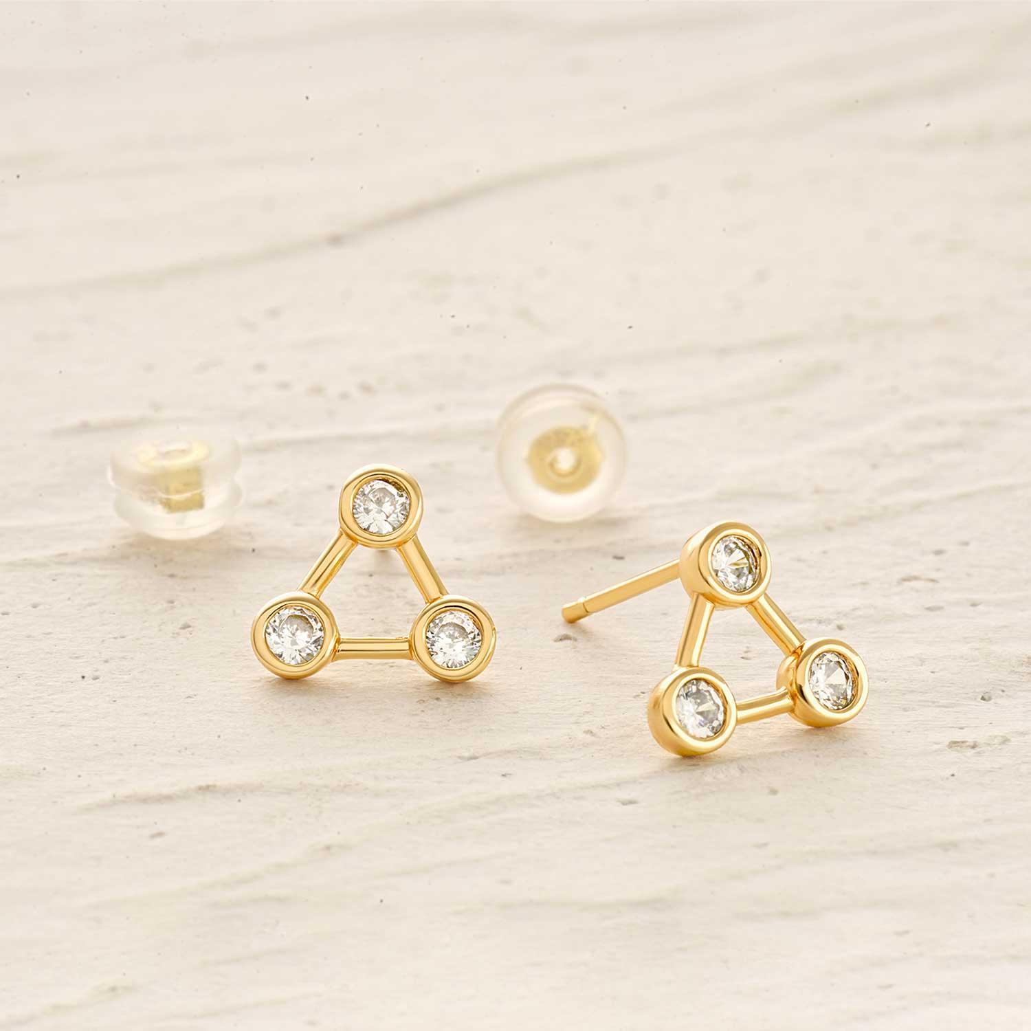 Detailed close-up of MYEARS mini triangle cubic zirconia stud earrings, highlighting gold finish and intricate design