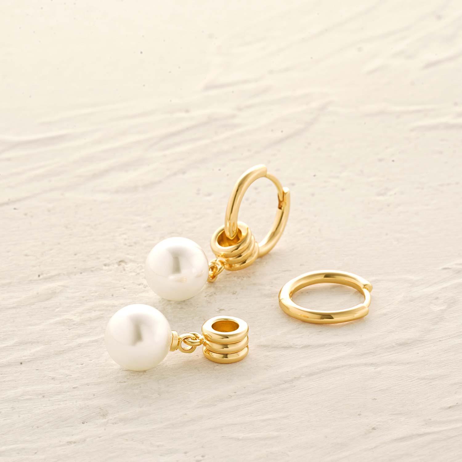 Detailed view of MYEARS® gold pearl drop huggie hoop earrings showing the secure huggie clasp and delicate pearl drop.