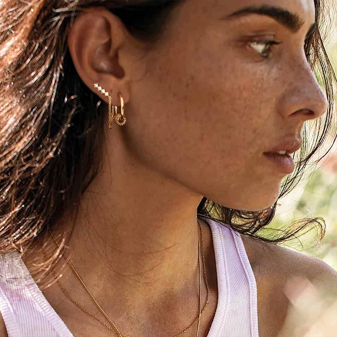 Close-up of model wearing MYEARS Quartet Chain Drop stud earrings in gold, elegant earrings for women