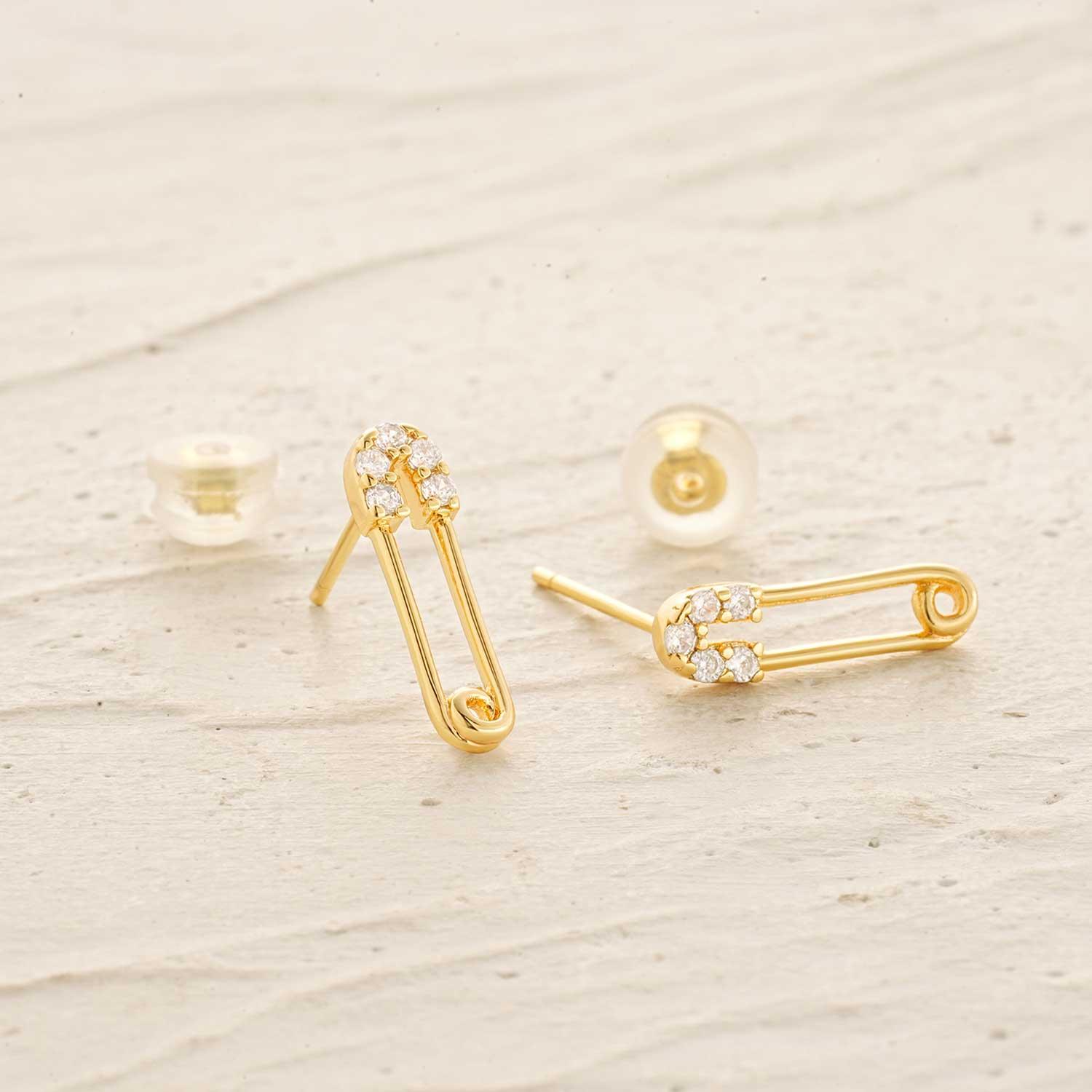 Detailed close-up of MYEARS Safety Pin Stud Earrings, showing gold finish and unique safety pin design