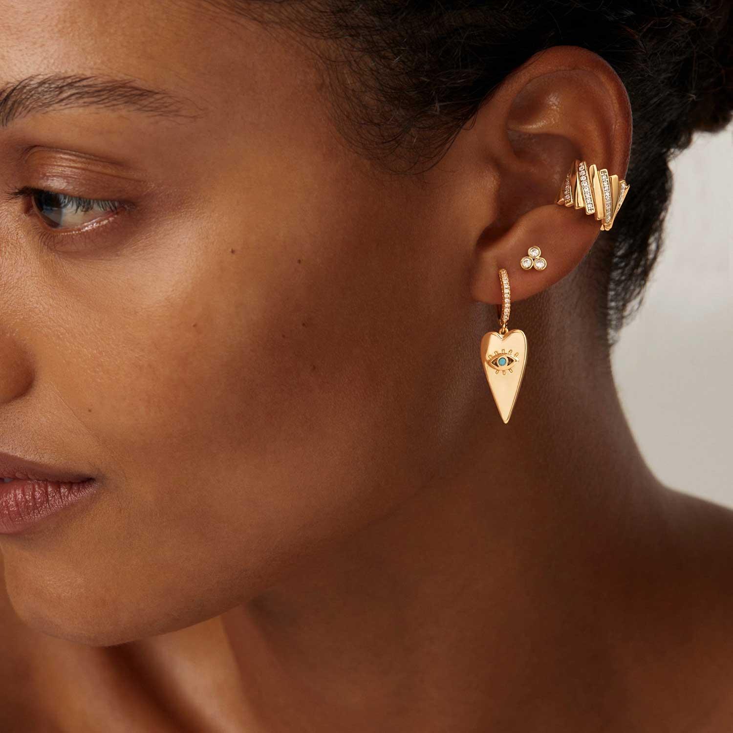 Close-up of MYEARS® turquoise evil eye heart drop earrings, gold heart drop design